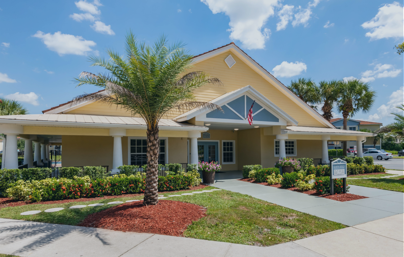 Leasing Office Exterior with palm tree and flower bed